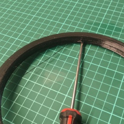 Jam a screwdriver into the seam between the support and the Rim Saver.